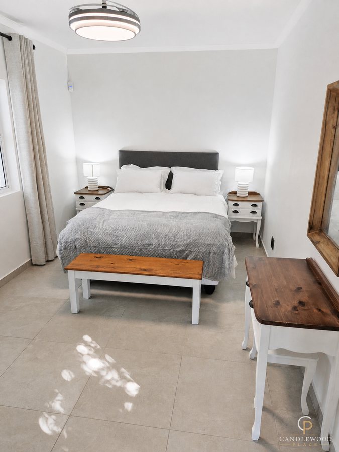 Queen bedroom with bedside lamps and a garden-facing window