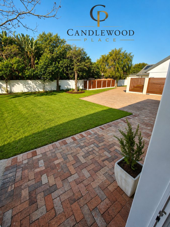 Private lawn and paved patio bordered by mature trees