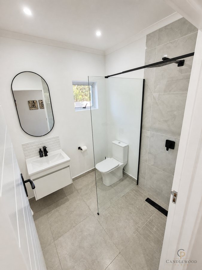 Guest bathroom with walk-in shower, basin and oval mirror