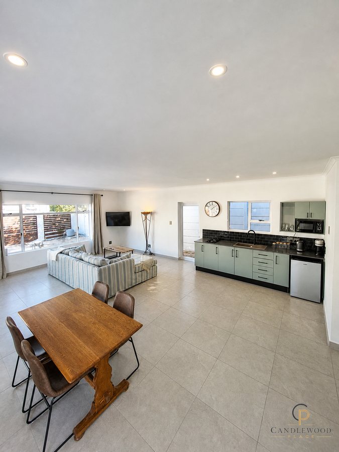 Open-plan living area with lounge, dining, kitchen and smart TV